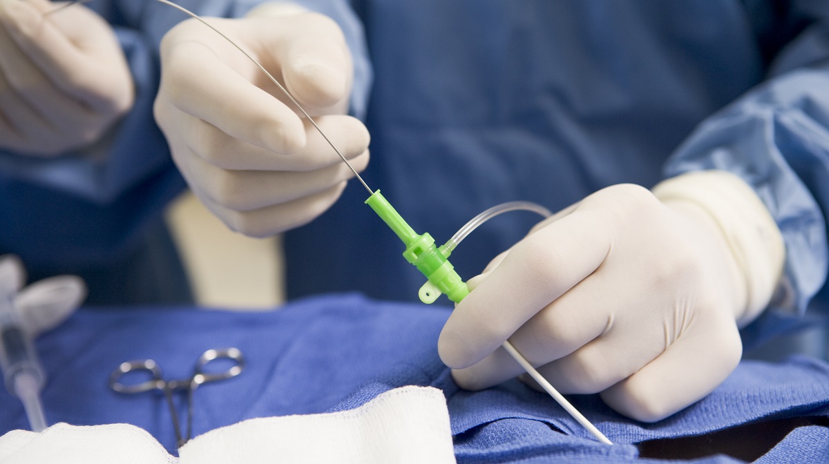 Surgeon Inserting Tube Into Patient During Surgery